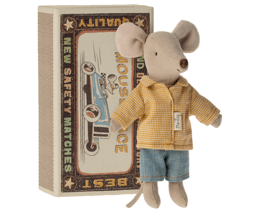 Petite souris grand frère Maileg avec sa boîte contenant un matelat, une couverture et un oreiller. Elle est habillée d'une chemise à carreaux et d'un bermuda en jean.